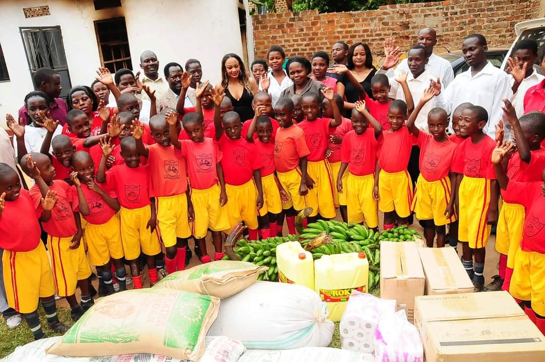 Children in school uniforms gathered with supplies during a Zari Foundation visit