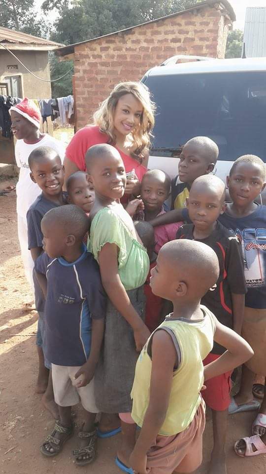 Zari Hassan standing outdoors with a group of children gathered around her during a neighbourhood visit