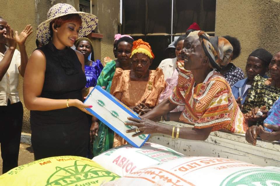 Zari Hassan handing packaged goods to an elderly woman during a household food distribution