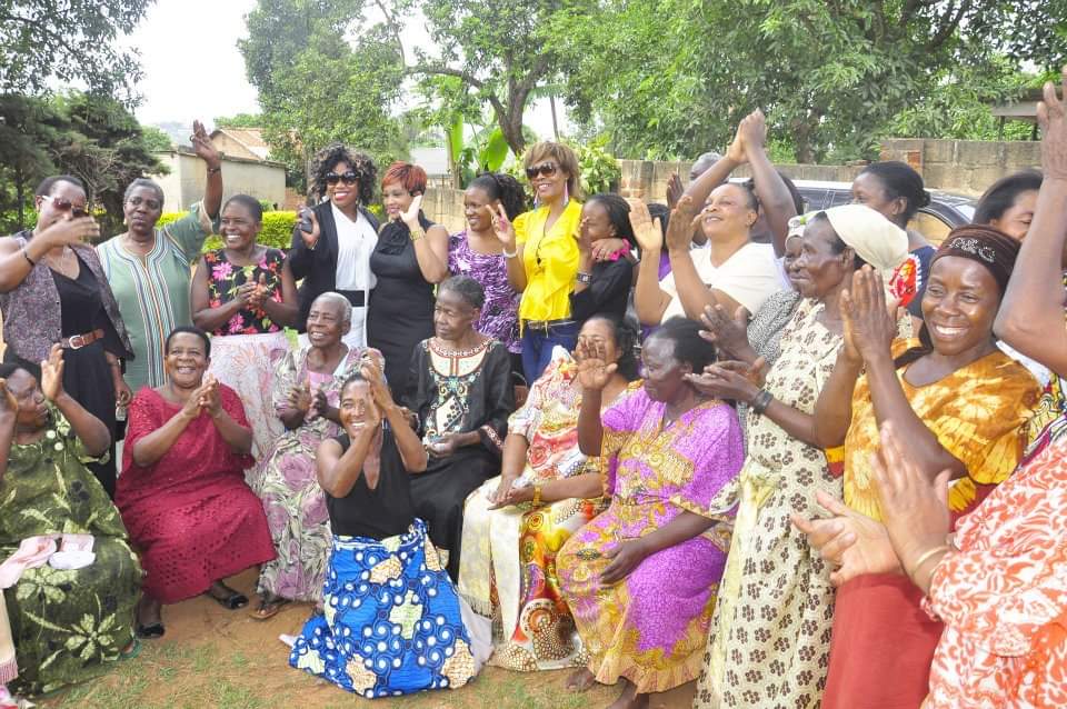 Zari Hassan with elders and community members clapping and celebrating together outdoors